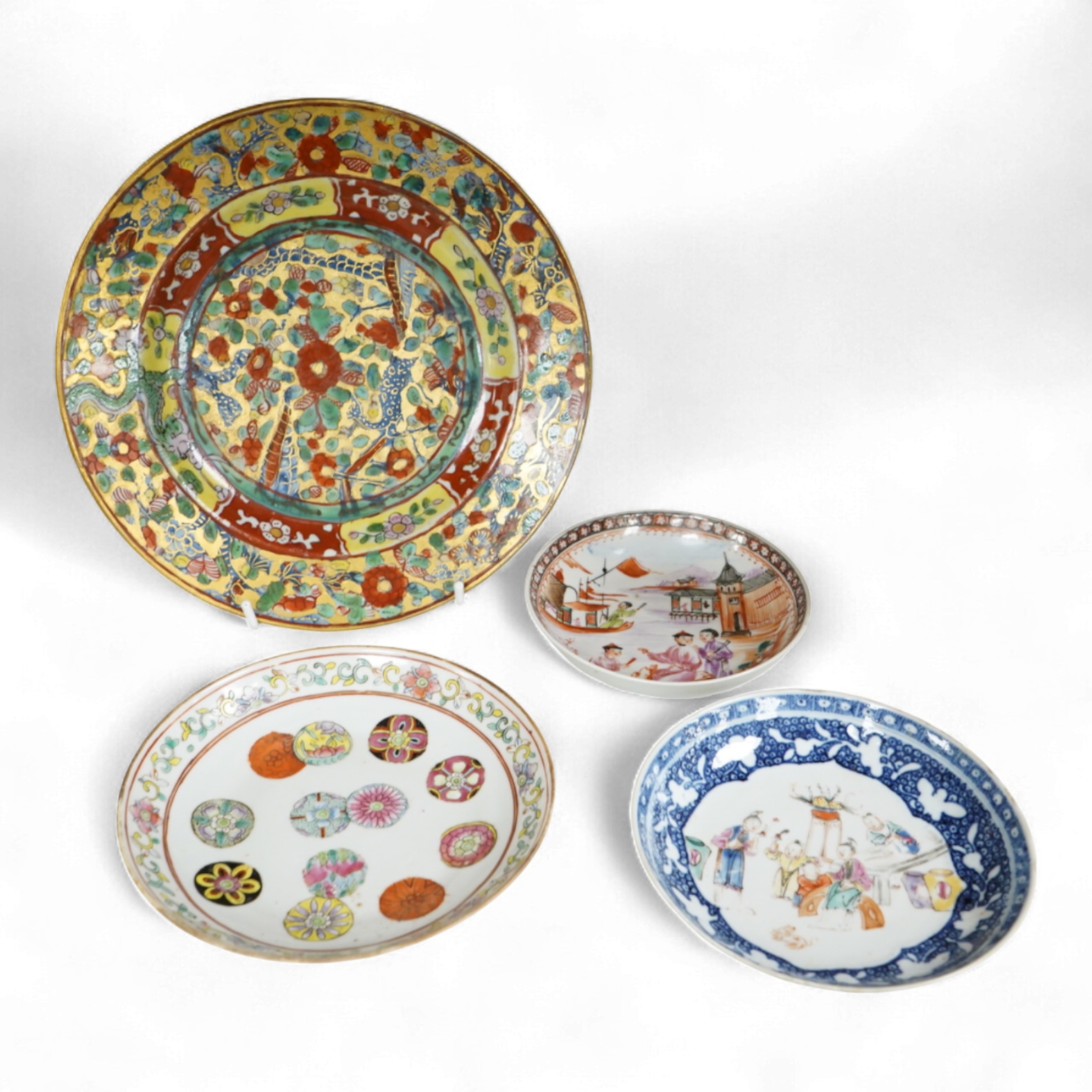An 18th century Chinese clobbered dish, a famille rose dish, Guangxu six character mark and two 18th century Chinese export saucers, largest 22cm